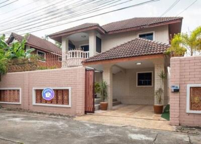 Exterior view of a residential house with tiled roof and gated entry