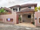 Exterior view of a residential house with tiled roof and gated entry