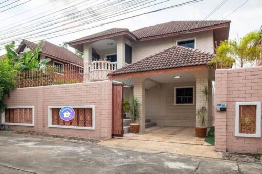 Exterior view of a residential house with tiled roof and gated entry