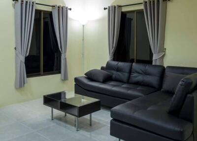 Living room with black leather corner sofa and coffee table