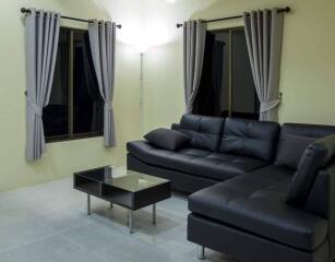 Living room with black leather corner sofa and coffee table