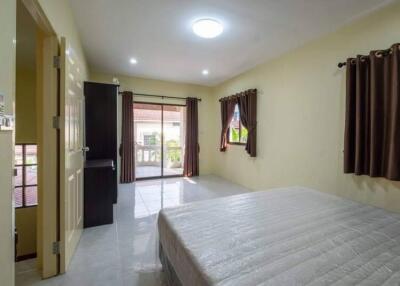 Spacious bedroom with curtains, a large bed, and access to a balcony