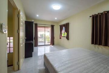 Spacious bedroom with curtains, a large bed, and access to a balcony