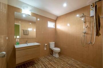 Modern bathroom with wooden-style floor tiles and wall-mounted sink