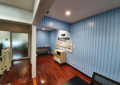 Modern office space with wooden flooring and blue wall panels