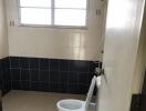 Bathroom with large window and tiled walls and floor