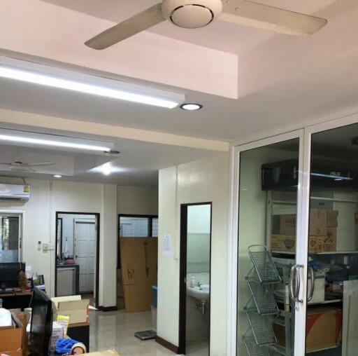 Interior of house with packed boxes, bathroom, shelving, and ceiling fan