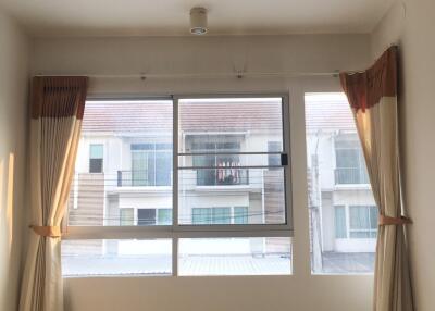 Bright and empty main living space with large windows and curtains