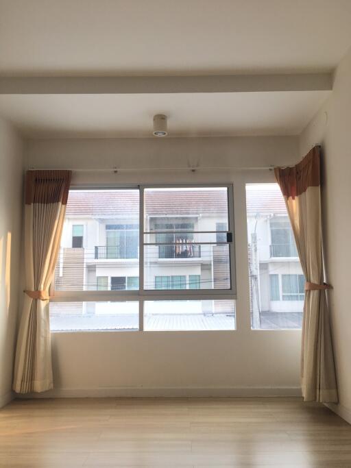 Bright and empty main living space with large windows and curtains