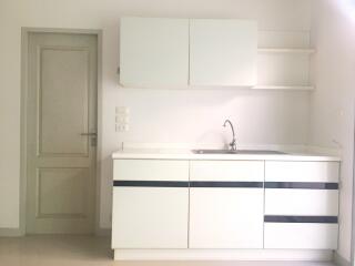 Modern minimalist kitchen with white cabinetry and sink