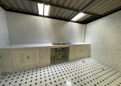 Simple white kitchen with tiled floors and double sink.