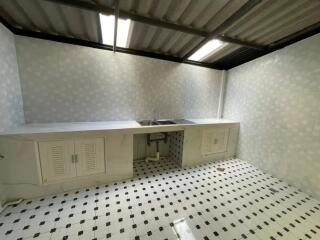 Simple white kitchen with tiled floors and double sink.