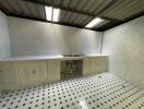 Simple white kitchen with tiled floors and double sink.