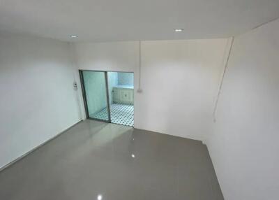 Spacious living room with tiled floor and adjacent kitchen