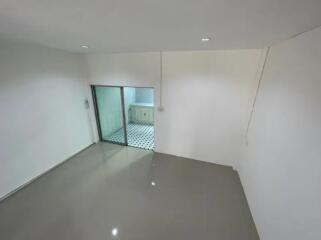 Spacious living room with tiled floor and adjacent kitchen