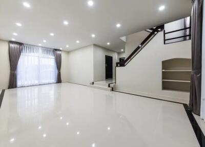 Spacious modern living room with large windows and staircase