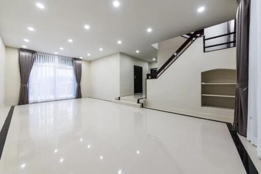 Spacious modern living room with large windows and staircase