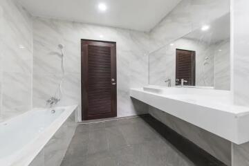 Modern bathroom with bathtub and large mirror