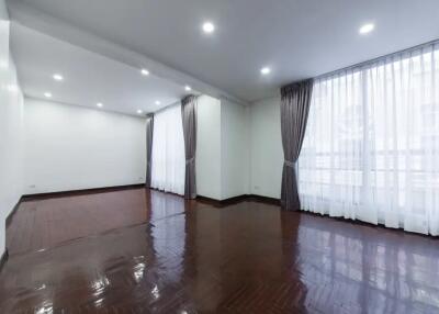 Spacious living room with large windows and curtains