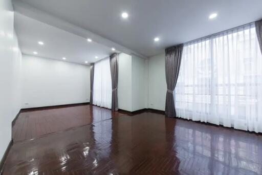 Spacious living room with large windows and curtains