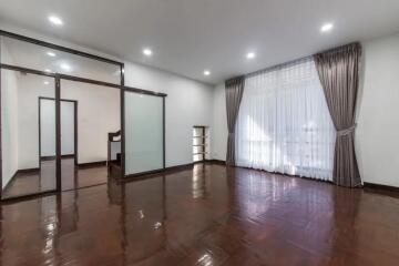 Spacious living room with large window and curtains