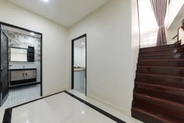 Modern hallway with access to bathroom and stairs