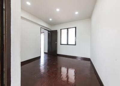 Empty bedroom with wooden floor and ceiling lights