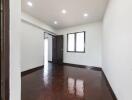 Empty bedroom with wooden floor and ceiling lights