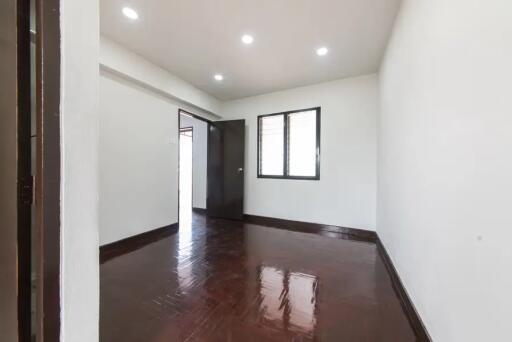 Empty bedroom with wooden floor and ceiling lights