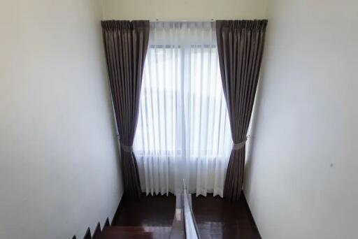 Staircase area with curtains over a window