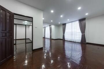 Spacious living room with large windows and wooden flooring