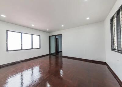 Spacious empty bedroom with wooden floor and large windows