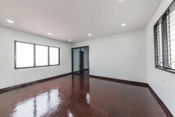 Spacious empty bedroom with wooden floor and large windows