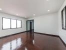 Spacious empty bedroom with wooden floor and large windows