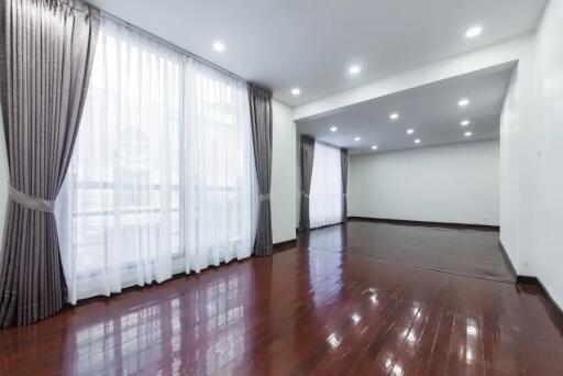 Spacious living room with hardwood flooring and large windows