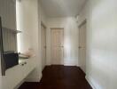 Hallway with three doors and a built-in shelf unit