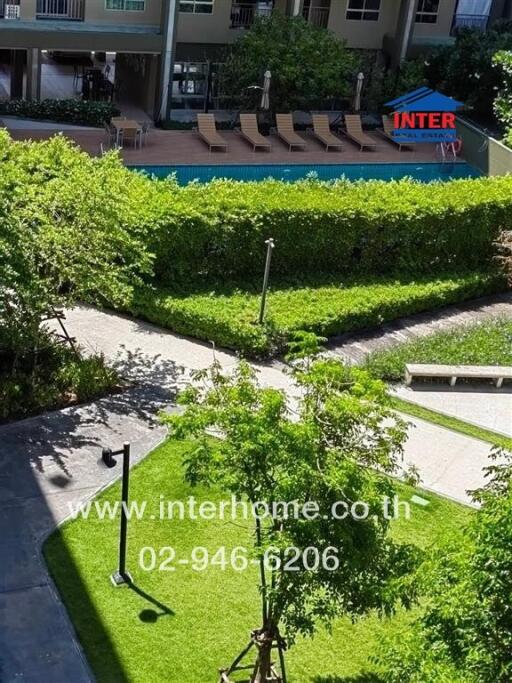 View from building overlooking lush courtyard and pool area