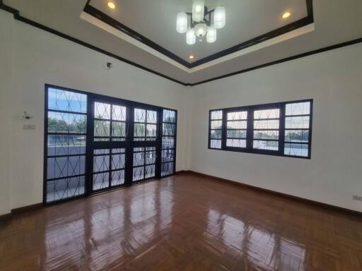 Spacious living room with large windows and elegant lighting