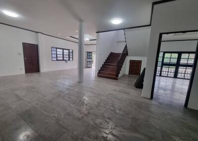 Spacious living room with tiled flooring and staircase