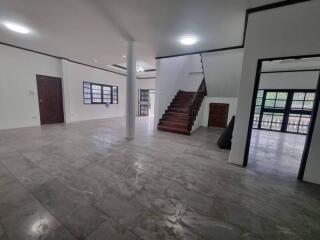 Spacious living room with tiled flooring and staircase