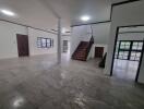 Spacious living room with tiled flooring and staircase