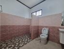 Spacious bathroom with tiled shower and toilet