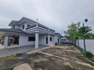 Large two-story house with driveway and garden