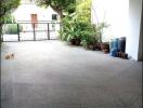 Covered parking area with potted plants and a gate