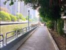 Scenic riverside walkway next to modern residential buildings