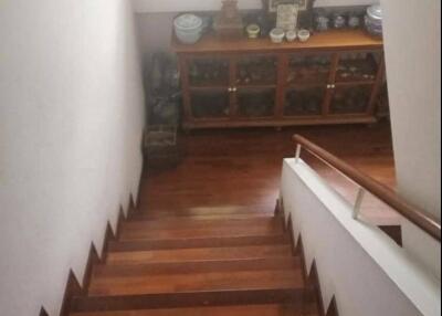 Wooden staircase leading to lower floor with decorative cabinet