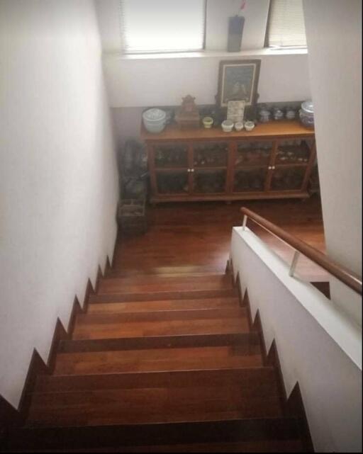 Wooden staircase leading to lower floor with decorative cabinet