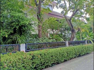 Front view of a residential building with a lush garden