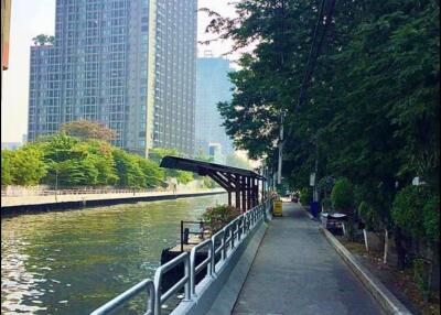 Riverside walking path with high-rise buildings in the background