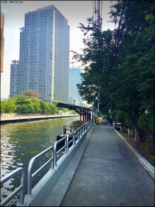 Riverside walking path with high-rise buildings in the background